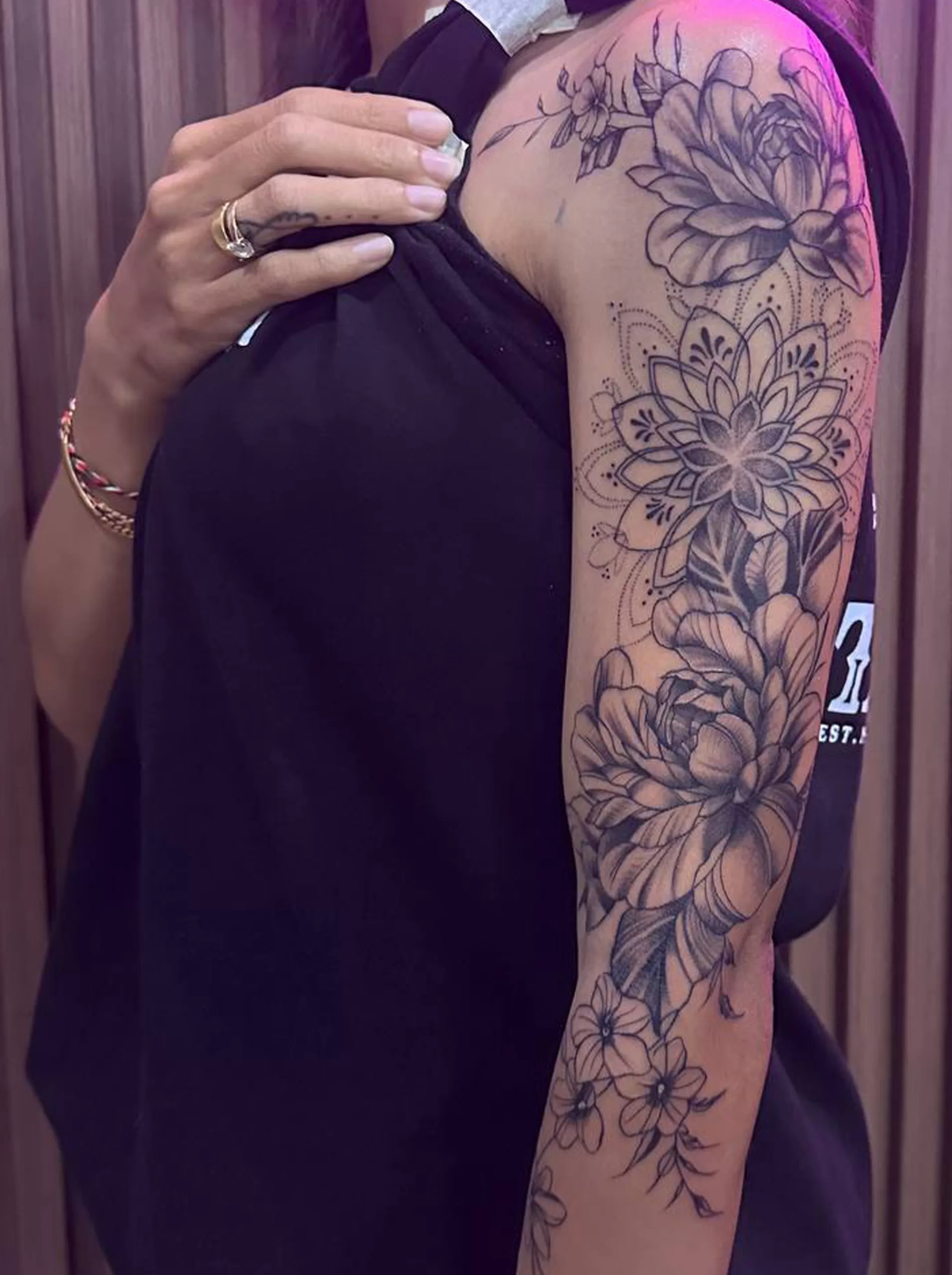 Botanical flower sleeve tattoo for women at Primitive Tattoo Bali - elegant floral arm design in Seminyak studio