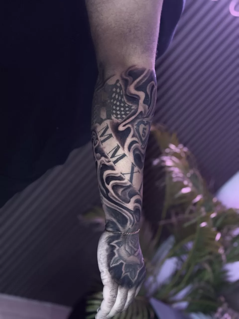 Men's forearm sleeve tattoo by Primitive Tattoo Bali - custom lower arm design with detailed black and grey work Seminyak