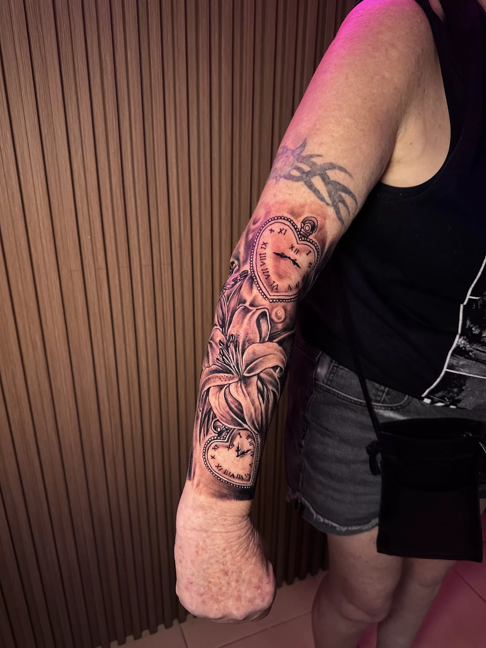 Women's sleeve tattoo featuring clock and flower design by Primitive Tattoo Bali - timeless feminine arm sleeve Seminyak
