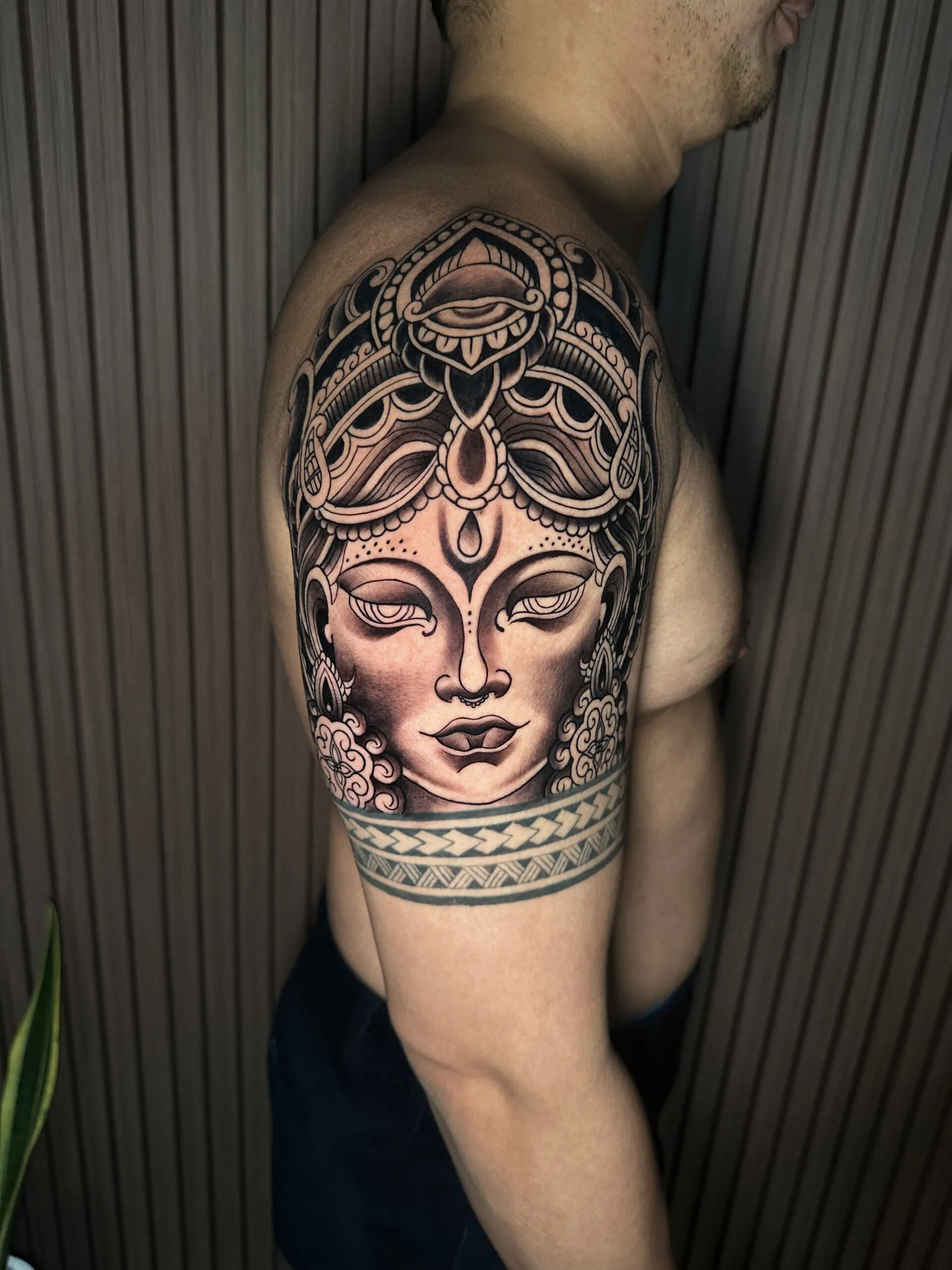 Intricate Buddha tattoo on shoulder